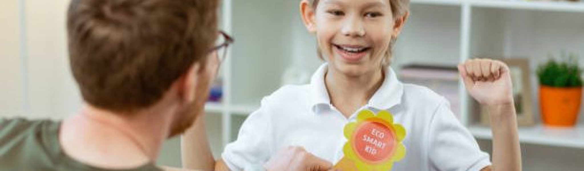 Bright rewarding sign. Contented proud boy being happy with his reward from pleasant elementary school teacher